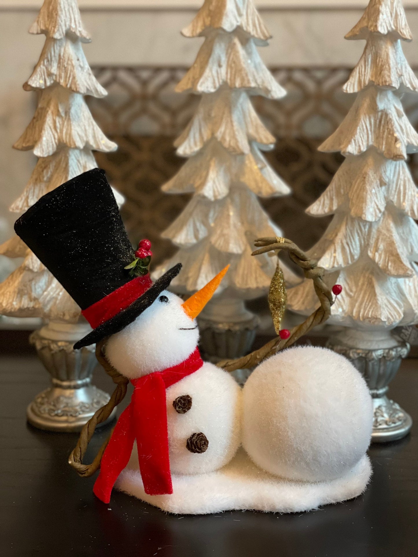 9.75” frosted snowman laying with star tabletop ornament